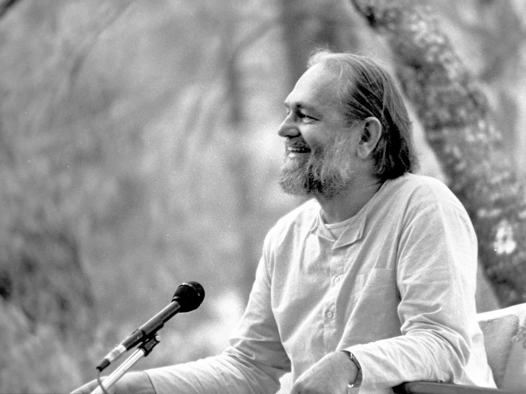 Swami Kriyananda smiles while giving a talk in the Temple of Trees at Ananda Village.
